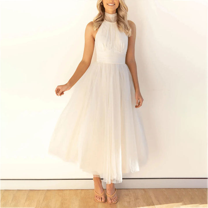 White sleeveless tulle dress with halter neck and full tiered skirt