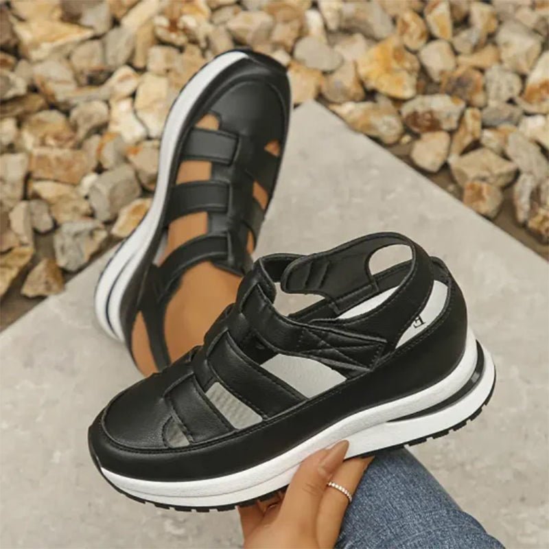 Black closed-toe sneaker sandals, front view with two straps and sporty platform sole