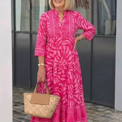 Pink button-front midi dress with V-neck and three-quarter sleeves, patterned tiered hem.