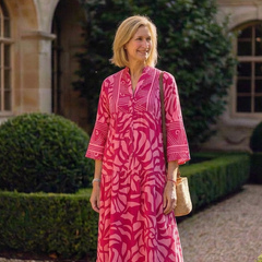 Pink button-front midi dress with V-neck and three-quarter sleeves, long tiered skirt.