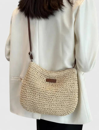 Beige woven half-moon shoulder bag with brown strap and front leather logo tab