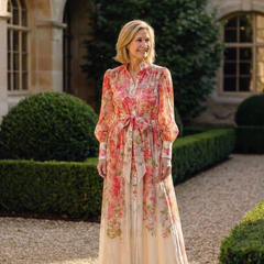 Floral sheer long-sleeve maxi dress with red floral print and tie waist, standing
